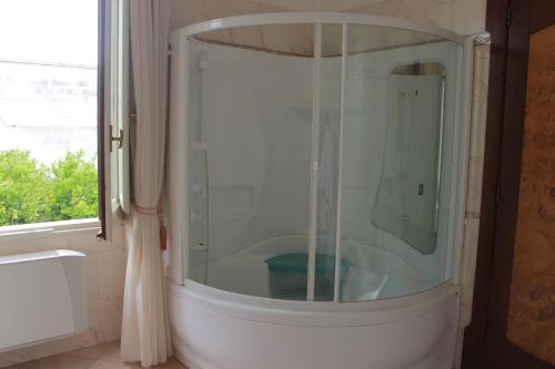 a glass shower in a bathroom with a window at Villa Li Putti Luxury B&B in Galatone