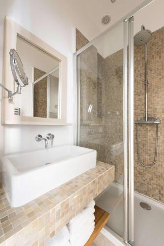 une salle de bain avec un lavabo blanc et une douche dans l'établissement Cada Vez, à Paris