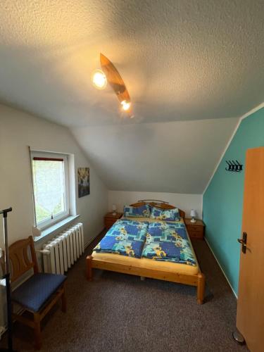 1 dormitorio con 1 cama y 1 silla en Fewo Auszeit Schwanow, en Rheinsberg