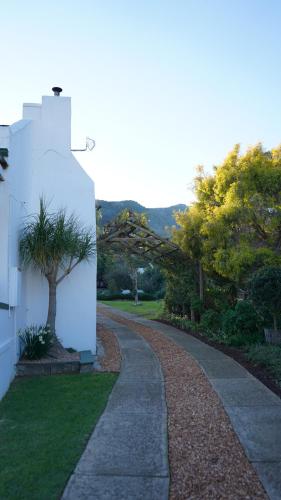 a winding road next to a white building at Over Karoo Inn in Barrydale