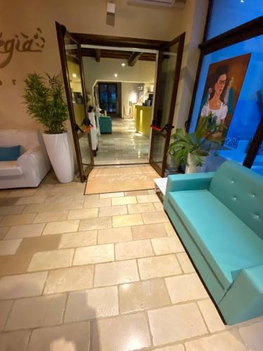 a living room with a blue couch and some plants at La Siègià Resort spa in Massa Marittima