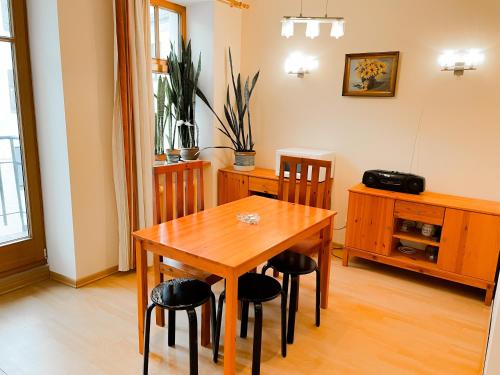 a dining room with a wooden table and chairs at Terbatas Apartment in Rīga