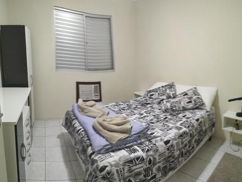 a bedroom with a bed with a black and white comforter at Apto 2 quartos, cond fechado, com vaga, quarto andar in Pelotas