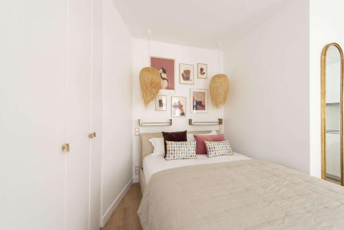 um quarto branco com uma cama com almofadas em Candide em Paris