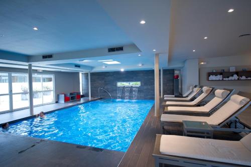 a large swimming pool with lounge chairs in a hotel room at Relais & Châteaux Le Brittany & Spa in Roscoff