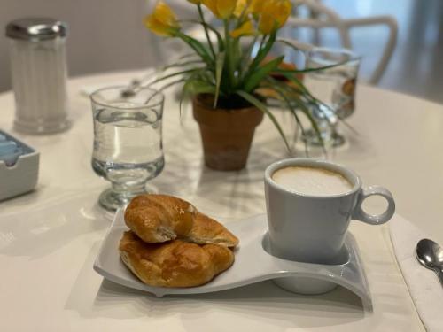 een bord met een kopje koffie en een gebakje bij Cristal Palace Hotel in Buenos Aires