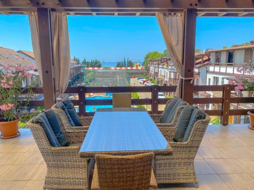 a table and chairs on a balcony with a view at Family Apart-Hotel Les Amis in Adler