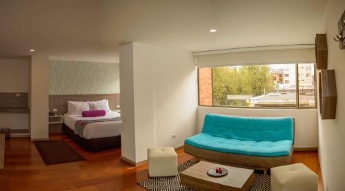 a hotel room with a bed and a blue chair at Hotel Confort 80 Zona Rosa in Bogotá