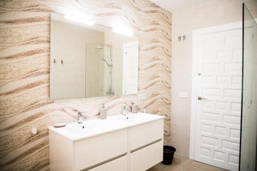 a bathroom with a white sink and a mirror at Family villa in Alicante, saltwater pool, AC and bbq in Alicante