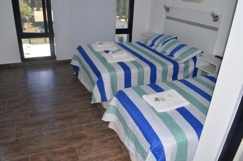 two beds with striped sheets in a room at JAK Colón in Colón