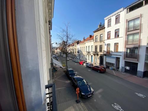 a person standing next to a street with a car at Grand Appartement Jourdan EU in Brussels