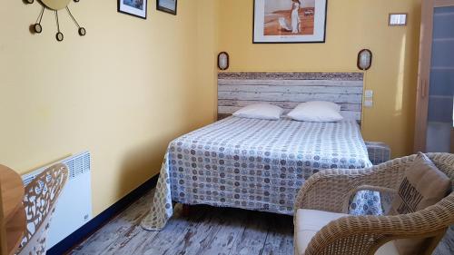 a small bedroom with a bed and two chairs at Hotel Vent d'Ouest in Fécamp