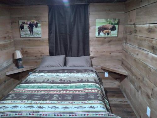 A bed or beds in a room at Cabin with a tree house on a buffalo farm .