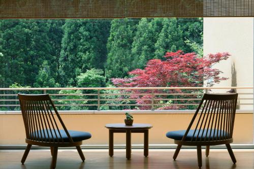 two chairs and a table in front of a window at 游泉志だて in Hanamaki