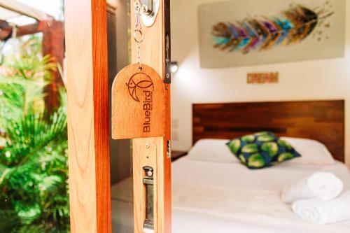 a room with a bed and a wooden door at Blue Bird in Bacalar