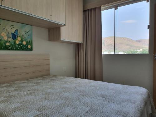 ein Schlafzimmer mit einem Bett und einem großen Fenster in der Unterkunft Park Veredas com acesso ao rio no fundo in Rio Quente