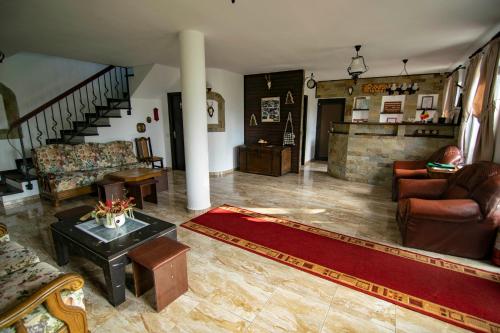 a living room with leather furniture and a staircase at Alpina Panoramic in Moisei