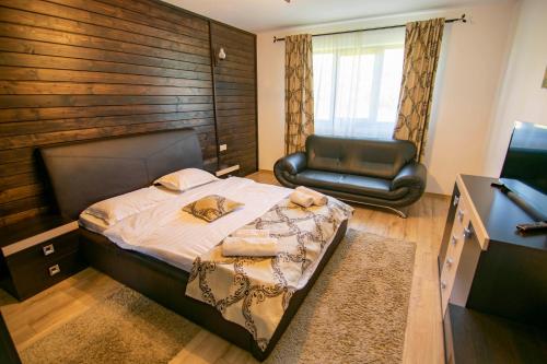 a bedroom with a bed and a chair at Alpina Panoramic in Moisei
