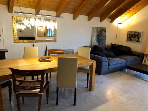 a living room with a wooden table and a couch at HeidiHoliday-Jenins Grand Maisonette-Attika mit Office & Relax-Bereich, Aussenparkplatz & Garage, geschützte Sonnen-Panoramaterrasse, Aufgewertet 2024 in Jenins
