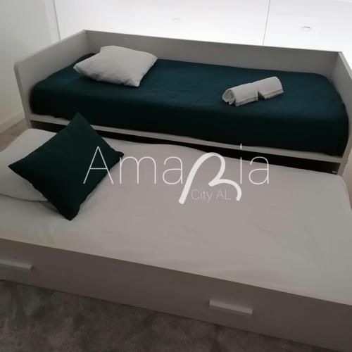 a bed in a room with a green and white mattress at AmaRiaCity AL in Aveiro