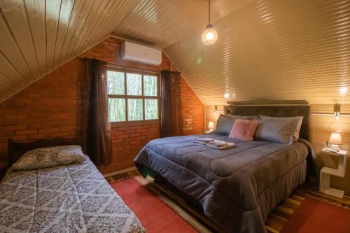 una camera da letto con un letto grande e una finestra di Pousada Refúgio da Alvorada a Praia Grande