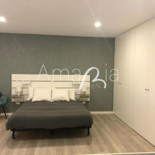 a bedroom with a bed with a sign on the wall at AmaRiaCity AL in Aveiro