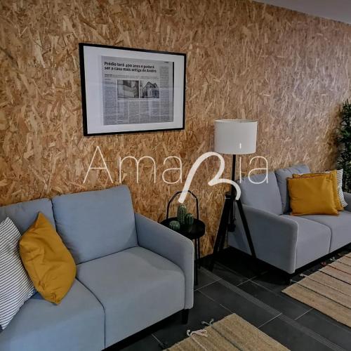 a living room with two couches and a sign on the wall at AmaRiaCity AL in Aveiro