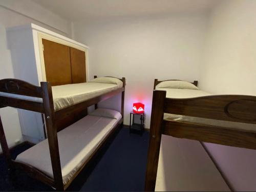 2 literas en una habitación con luz roja en Hostel Playa Grande Güemes en Mar del Plata