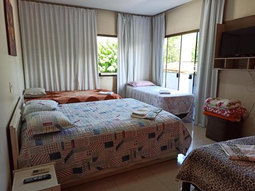 a hotel room with two beds and a window at Pousada das Orquideas Foz in Foz do Iguaçu