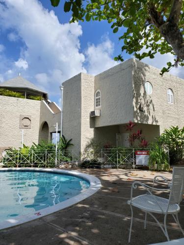 a house with a swimming pool in front of it at Emerald Garden in Ocho Rios