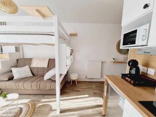 a small apartment with a bunk bed and a couch at PIVOINE -12 Min des parcs Walt Disney-Arrivée autonome-Wifi&Parking gratuit in Montévrain