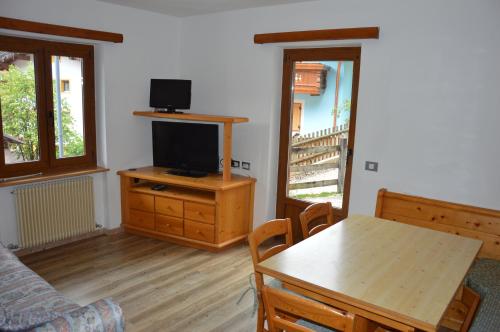 a living room with a table and a television at Cèsa Soracrepa in Canazei