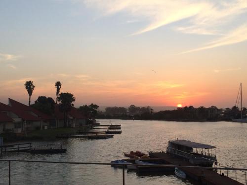 a group of boats on the water at sunset at First Group Port Owen Marina in Velddrif