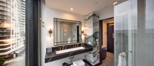 bagno con lavandino e specchio di The Godfrey Hotel Hollywood a Los Angeles