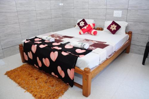 a bedroom with a bed with hearts on it at Aryan residency in Māvalli