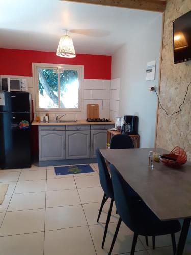 a kitchen with a table and chairs in a room at Ti Kaban Letchi in Le Tampon