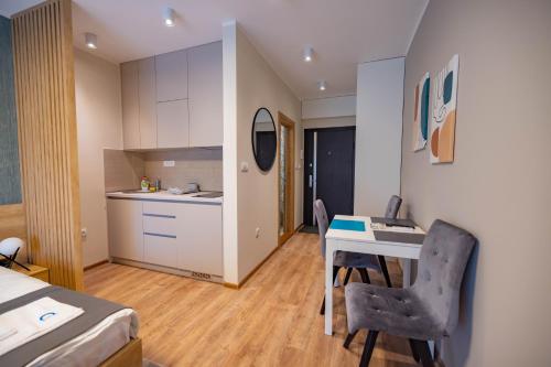 a room with a desk and a kitchen and a bed at Omega Apartments in Vrnjačka Banja