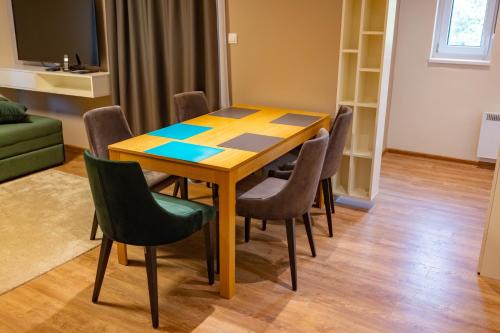 a dining room table and chairs in a room at Omega Apartments in Vrnjačka Banja