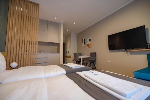 a hotel room with two beds and a flat screen tv at Omega Apartments in Vrnjačka Banja