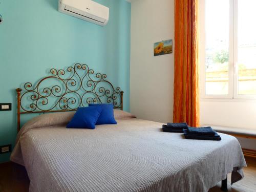 a bedroom with a bed with two blue pillows on it at Casa Matuzia in Sanremo