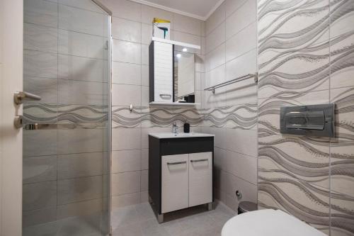 a bathroom with a toilet and a sink and a mirror at Omega Apartments in Vrnjačka Banja