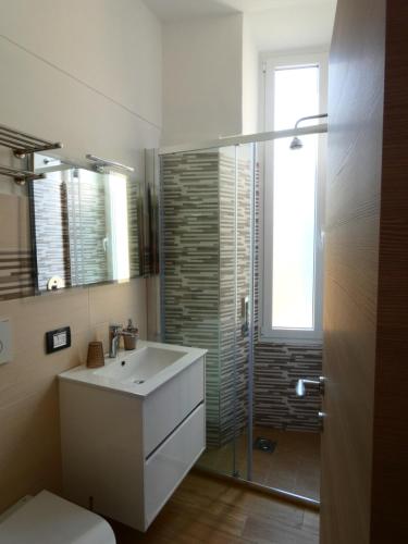 uma casa de banho com um lavatório e uma cabina de duche em vidro. em Casa Matuzia em Sanremo