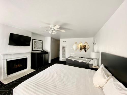 a white and black room with a white stove and a white bed at Masterpiece Hotel in Morro Bay