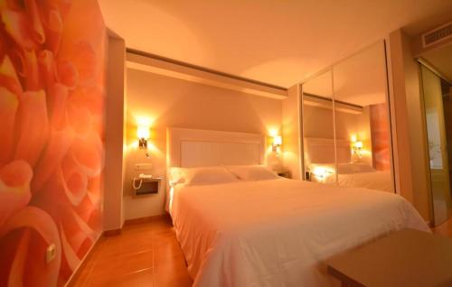 a hotel room with a white bed and a mirror at Hotel Jucamar in Cangas de Morrazo
