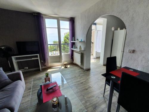 a living room with a couch and a table at Appartement VUE MER avec parking gratuit sur place in Bastia