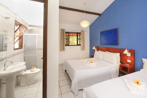 a bedroom with two beds and a bathroom at Pousada Arriba Pipa in Pipa