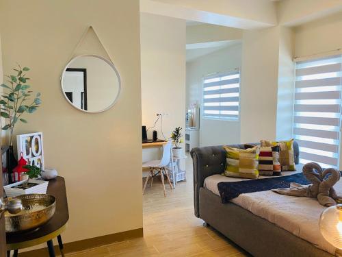 uma sala de estar com um sofá e um espelho em Lower Penthouse Suite Lafayette Park Square Megaworld Blvd em Iloilo
