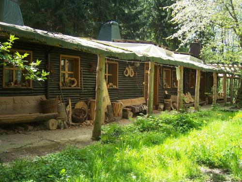 stary drewniany dom z namiotem na dziedzińcu w obiekcie Das wilde Auwaldhaus w mieście Bertsdorf