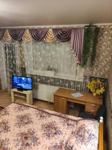 a room with a bed and a desk and a television at Oasis Apartments in Pärnu