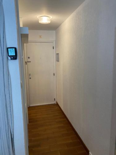 a hallway with a white door and a television at My Fair - Koksijde in Koksijde